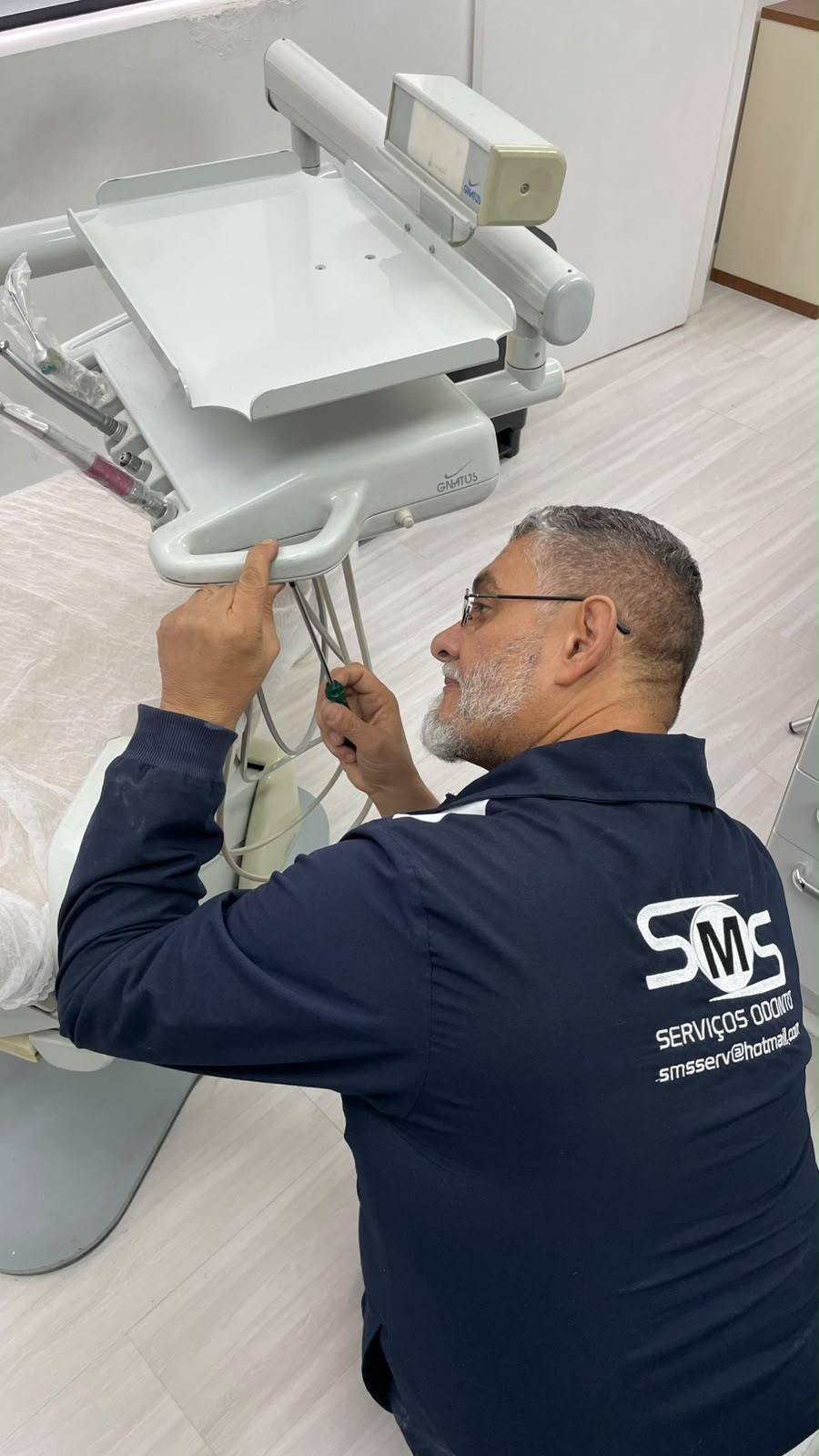 Técnico da SMS realizando manutenção em equipamento odontológico Gnatus