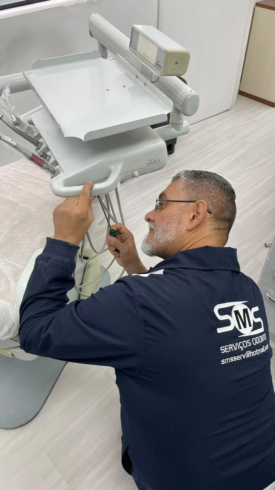 Técnico da SMS realizando manutenção em equipamento odontológico Gnatus